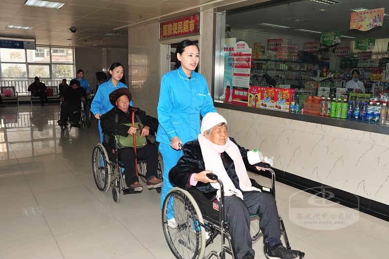院内服务组用轮椅推送老人们到眼科中心